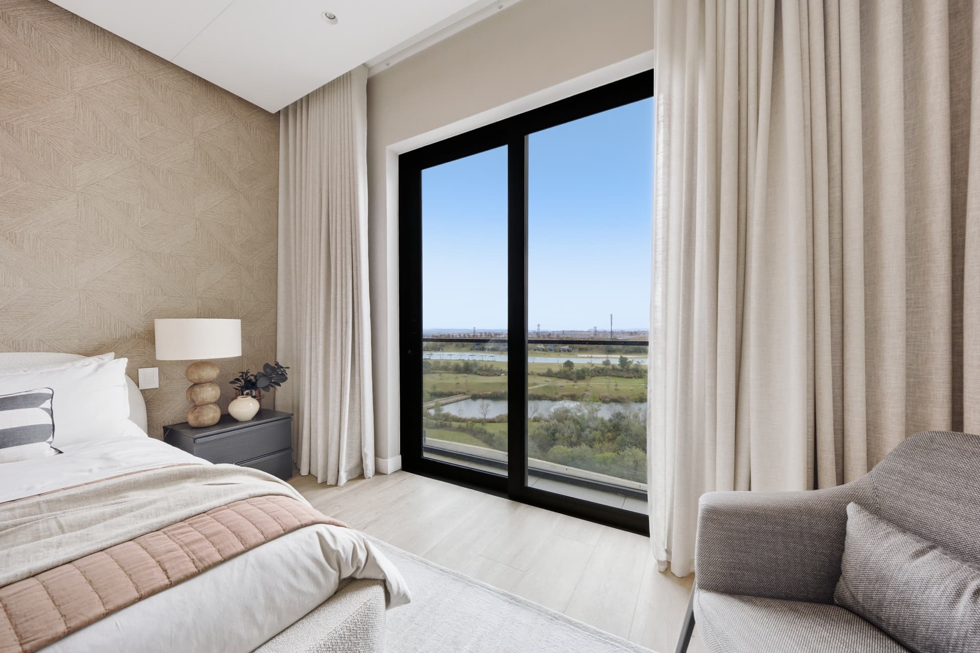 Bedroom with floor-to-ceiling glass doors opening to a balcony